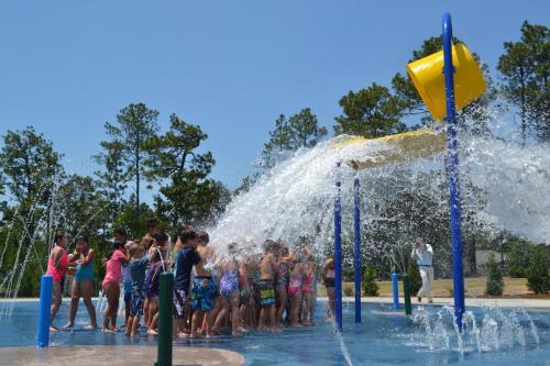 a group of children playing in a fountain at Legends and Masters Iron Suite in Pinehurst
