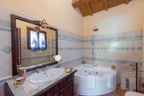 un bagno con vasca e lavandino di Santa Croce Resort a Torgiano