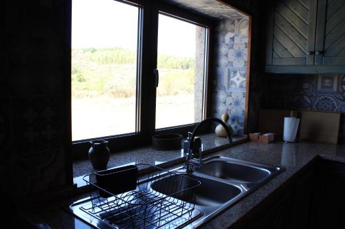 w kuchni z umywalką i oknem w obiekcie Quinta Do Marmeiral w mieście Mangualde