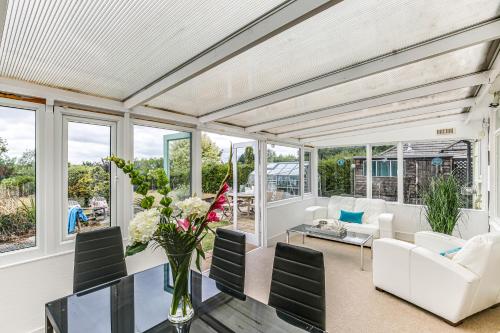 a living room with white furniture and windows at LOCHIEL in Tatsfield