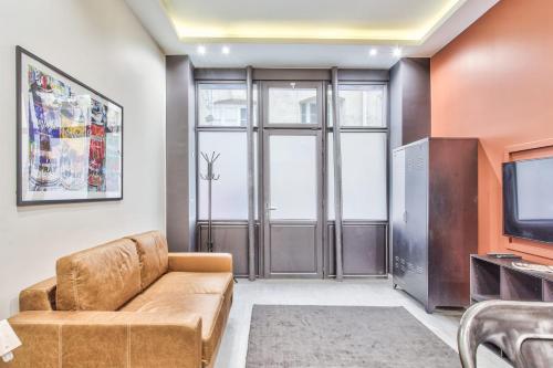un salon avec un canapé et une télévision dans l'établissement Studio Rambuteau - Welkeys, à Paris