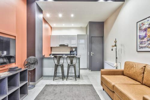 un salon avec un canapé et une cuisine dans l'établissement Studio Rambuteau - Welkeys, à Paris