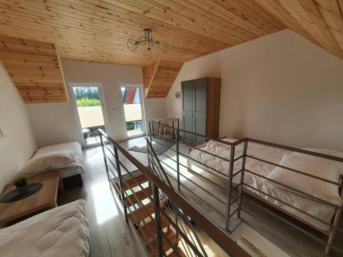 a room with two bunk beds and a wooden ceiling at Domki Apartamentowe 3Fale in Władysławowo