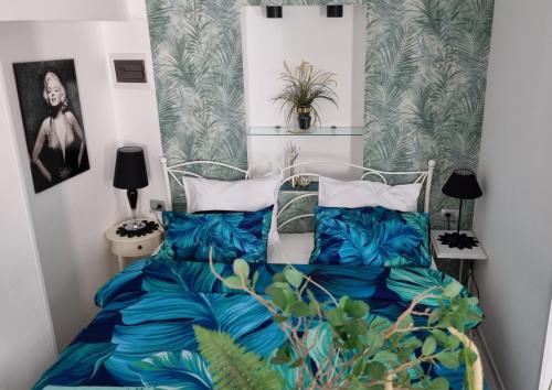 een slaapkamer met een bed met blauwe lakens en planten bij App Paris 5 in Umag