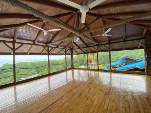 a large room with large windows and a wooden floor at Horizon Hotel & Yoga Center in Santa Teresa Beach