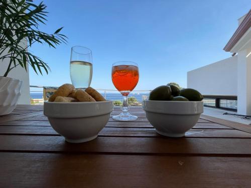 una mesa con un bol de fruta y una copa de vino en Sea House IUN Q7317 en Santa Maria Navarrese