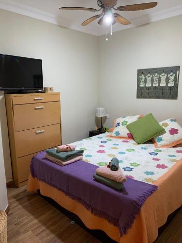 a bedroom with a bed with a dresser and a tv at Apartamento Playa Chica in Puerto de Santiago