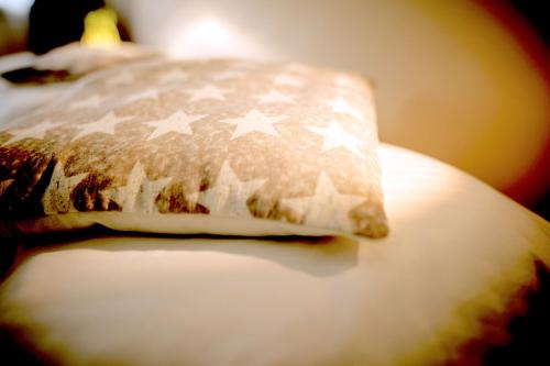 a pillow with stars on it sitting on a bed at Das Hotel Stern, B&B KG - digital & contactless check-in in Sankt Gilgen
