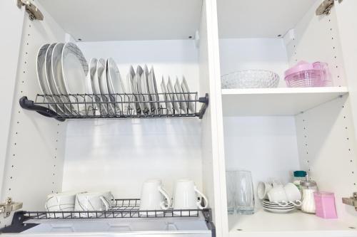 a kitchen pantry with plates and dishes on a shelf at Sonrisa Deluxe Apartments, Levante in Benidorm
