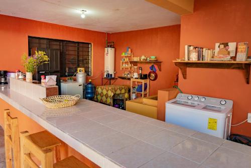 a kitchen with orange walls and a counter top at Casa Sofia Guest House in San Cristóbal de Las Casas