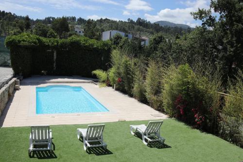 two chairs and a swimming pool in a yard at Casa dos Remendos - Alojamento Local in Termas de Sao Pedro do Sul