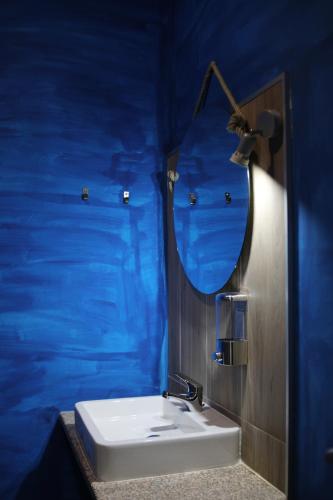 a blue bathroom with a sink and a mirror at Casa dos Remendos - Alojamento Local in Termas de Sao Pedro do Sul