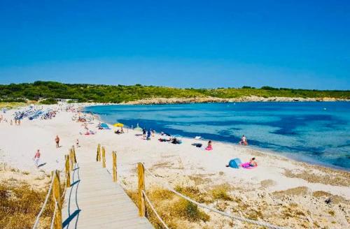 a group of people on a beach near the water at FLAT Surrounded by Nature WIFI & Pool & beach Nearby in Son Parc