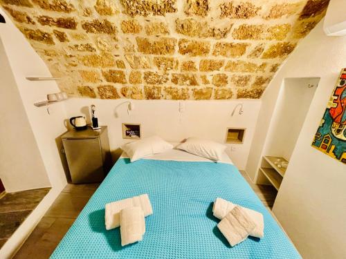 a bedroom with a blue bed with towels on it at Vecchia Casa kamara in Monemvasia