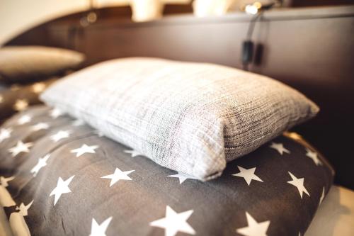 a pillow on a bed with stars on it at Das Hotel Stern, B&B KG - digital & contactless check-in in Sankt Gilgen