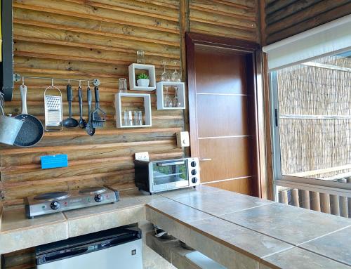 a kitchen with wooden cabinets and a stove at Horizon Hotel & Yoga center in Santa Teresa Beach