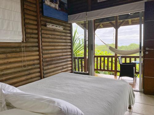 a bedroom with a bed and a balcony with a hammock at Horizon Hotel & Yoga center in Santa Teresa Beach