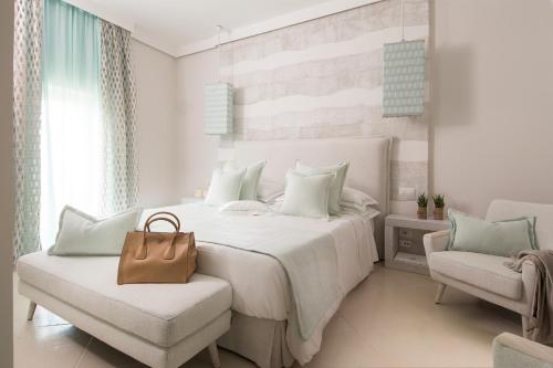 a bedroom with a white bed with a brown purse on it at San Michele Suite in Polignano a Mare