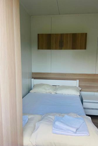 ein Schlafzimmer mit einem großen Bett mit weißer Bettwäsche in der Unterkunft Zajazd we Młynie - Domki letniskowe in Lubięcin
