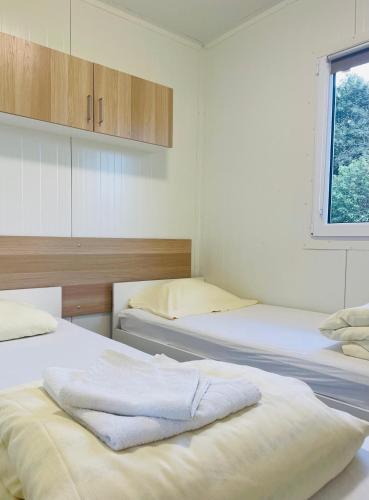 Zimmer mit 3 Betten und einem Fenster in der Unterkunft Zajazd we Młynie - Domki letniskowe in Lubięcin