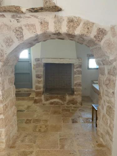 a room with a stone fireplace in a house at Masseria Capece in Cisternino