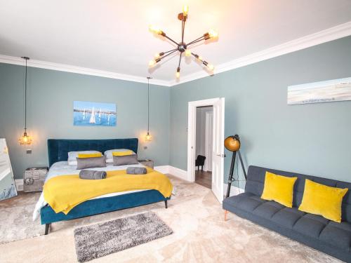 a blue bedroom with a bed and a couch at Swanage Bay in Swanage