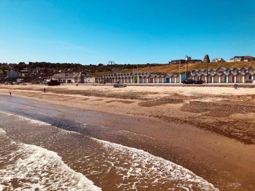 a sandy beach with a building in the background at Swanage Bay in Swanage