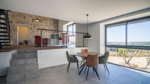 une cuisine et une salle à manger avec une table et des chaises dans l'établissement Maison de la Besse, à Peaugres