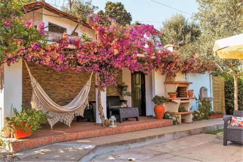 a house with a hammock and flowers on it at Cosy Countryside - Family House in Castelo de Paiva