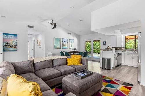 a living room with a couch and a kitchen at Poolside Palm Springs Paradise in Palm Springs
