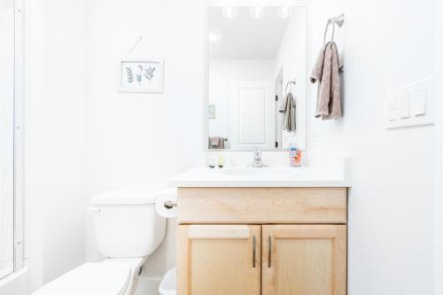 uma casa de banho com um lavatório, um WC e um espelho. em Downtown Getaway em Anchorage
