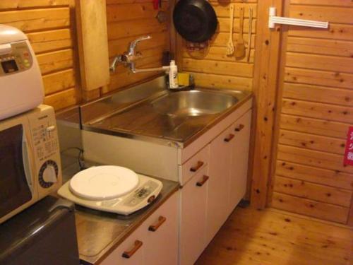 a small kitchen with a sink and a microwave at Cottage Izu,com - Vacation STAY 07073v in Minamiizu