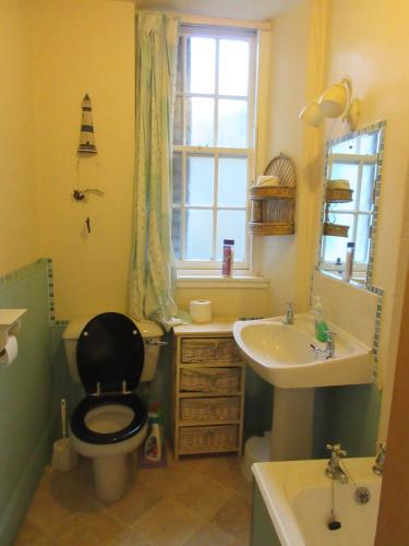 a bathroom with a black toilet and a sink at Anchor House in Pittenweem