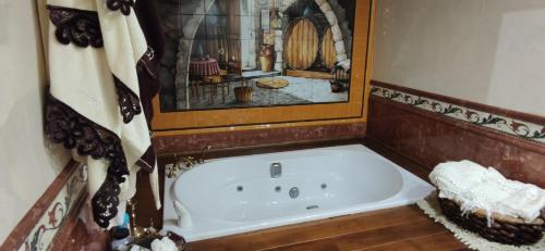 a bath tub in a bathroom with a painting on the wall at VILLA DOLARETXE by Urdaibai Rentals in Bilbao