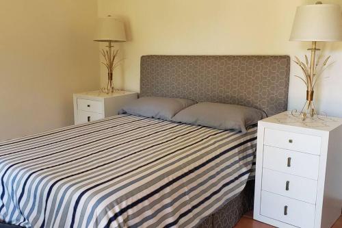 a bedroom with a bed with two night stands and two lamps at Casita Jardin de Mariposas El Tuito in El Tuito