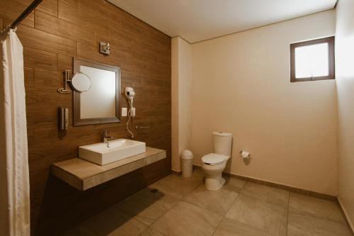 a bathroom with a sink and a toilet at Hotel Guivá Aeropuerto in Oaxaca City