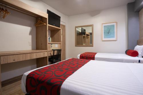 een hotelkamer met 2 bedden en een bureau bij Hotel Roble in Mexico-Stad
