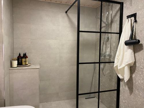 a shower with a glass door in a bathroom at Moderni ullakkohuoneisto in Kuopio