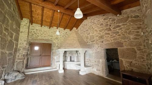 Zimmer mit einer Steinmauer und einer Holztür in der Unterkunft Terra Alta do Furnia in Tui