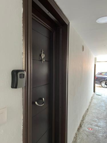 a black door with a handle in a hallway at Charming House in Pogradec