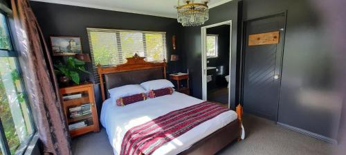a bedroom with a bed and a chandelier at Waitapu Springs B&B in Takaka