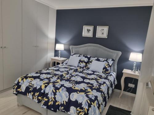 een slaapkamer met een bed met een blauwe muur bij RosA II in Gdynia