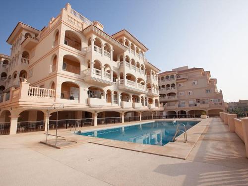 a large building with a swimming pool in front of it at Porto fino almerimar in Almerimar