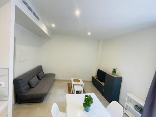 ein Wohnzimmer mit einem Sofa und einem Tisch in der Unterkunft NICE CENTRIC APARTMENT in Vilanova i la Geltrú