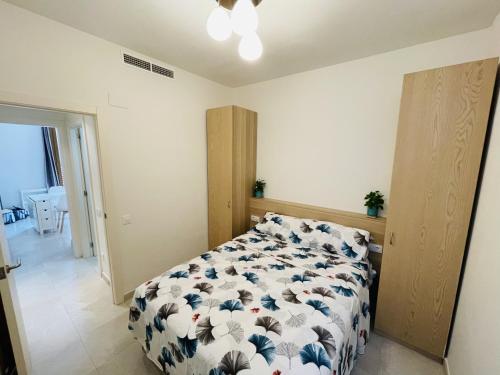 a bedroom with a bed with a blue and white comforter at NICE CENTRIC APARTMENT in Vilanova i la Geltrú