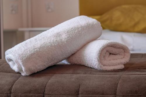 a roll of white towels sitting on top of a bed at Wrzos & Belvedere in Kudowa-Zdrój
