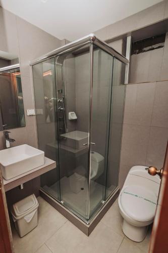 a bathroom with a glass shower and a toilet at Hotel Los Reyes in Cajamarca