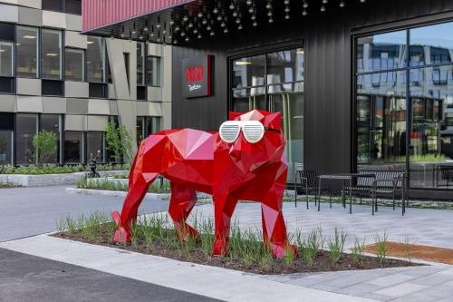 a red sculpture of a bear in front of a building at Radisson RED Oslo Okern in Oslo