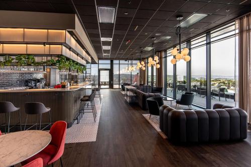 a restaurant with a bar and tables and chairs at Radisson RED Oslo Økern in Oslo