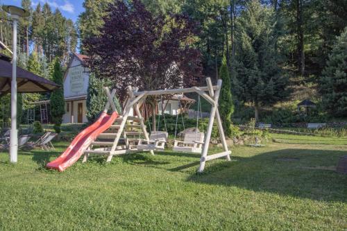 een speeltuin met een glijbaan in het gras bij Wrzos & Belvedere in Kudowa-Zdrój